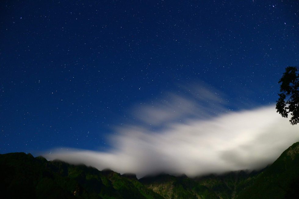 雲がかかった穂高連峰の稜線と星空